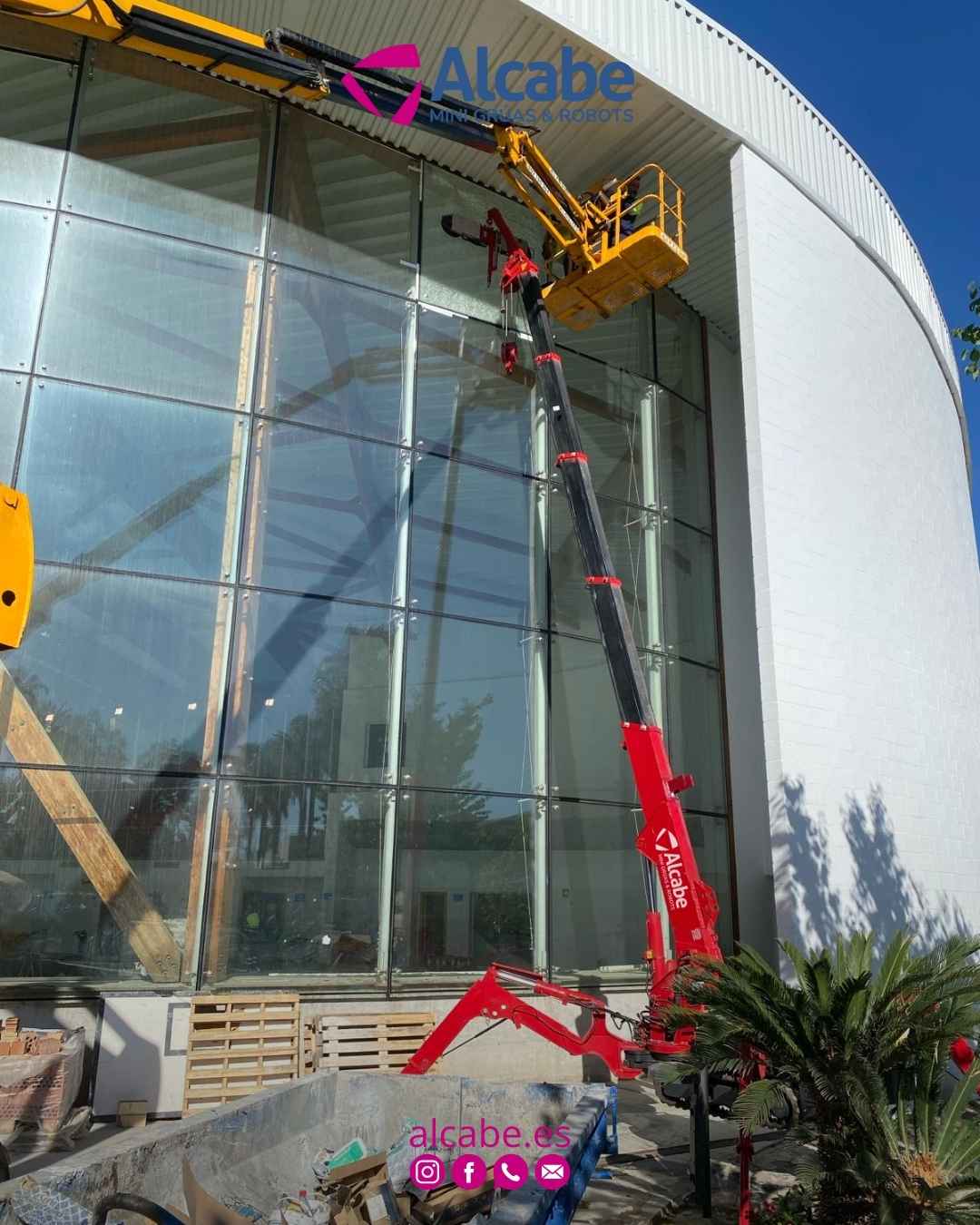 Nuestra mini grúa, elevando y colocando cristales en fachada de edificio empresarial en Alhaurín el Grande (Málaga).