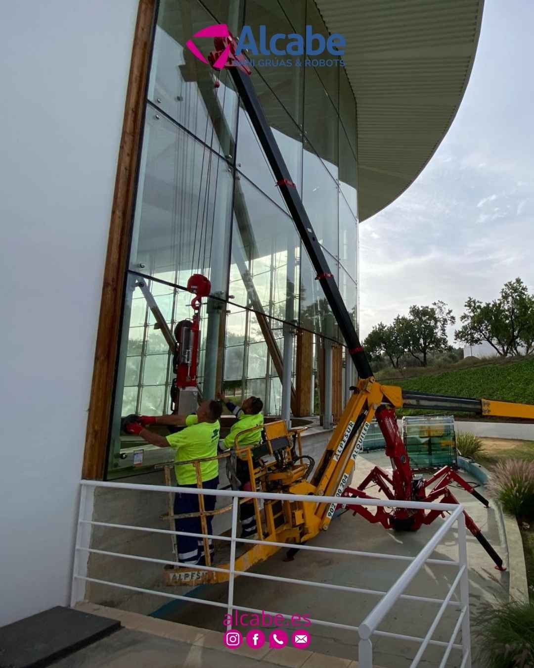 Nuestra mini grúa, elevando y colocando cristales en fachada de edificio empresarial en Alhaurín el Grande (Málaga).