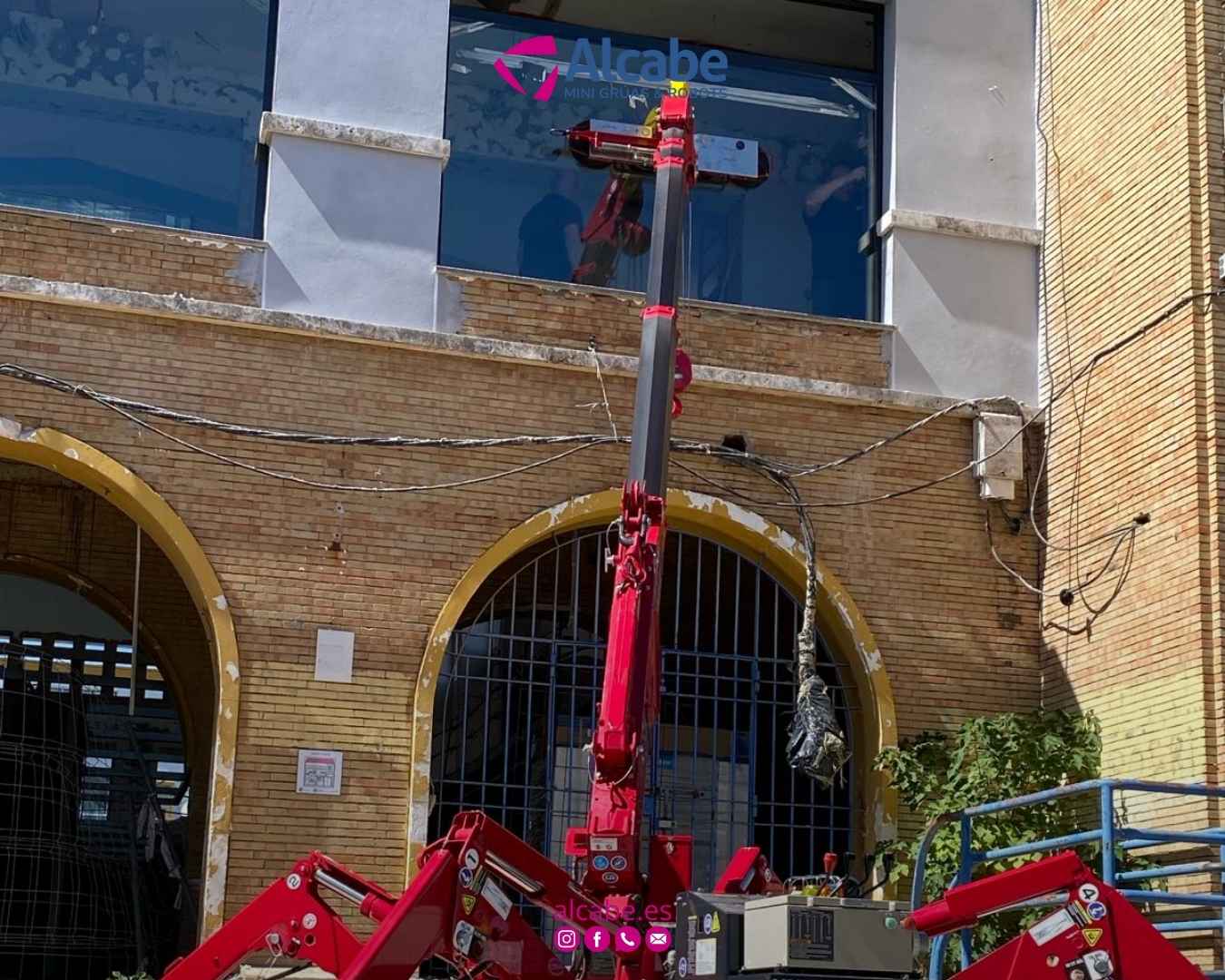 Mini grúa colocando cristales en un colegio de Huelva