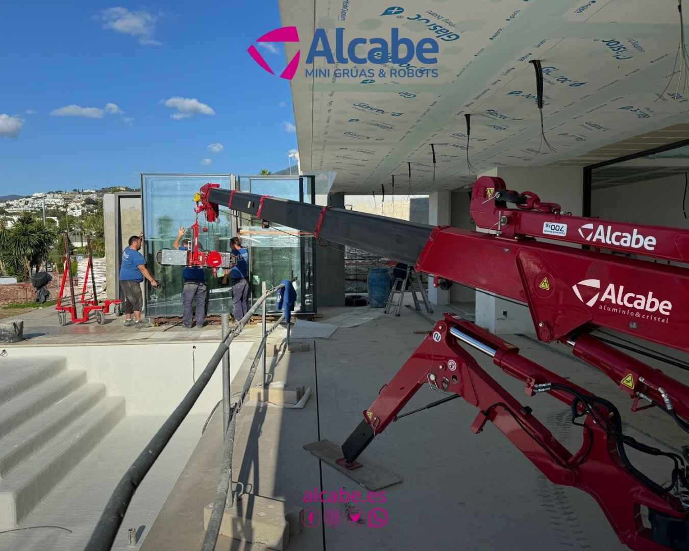 Alquiler de mini grúa en Marbella para la colocación de vidrios en un chalet de lujo.