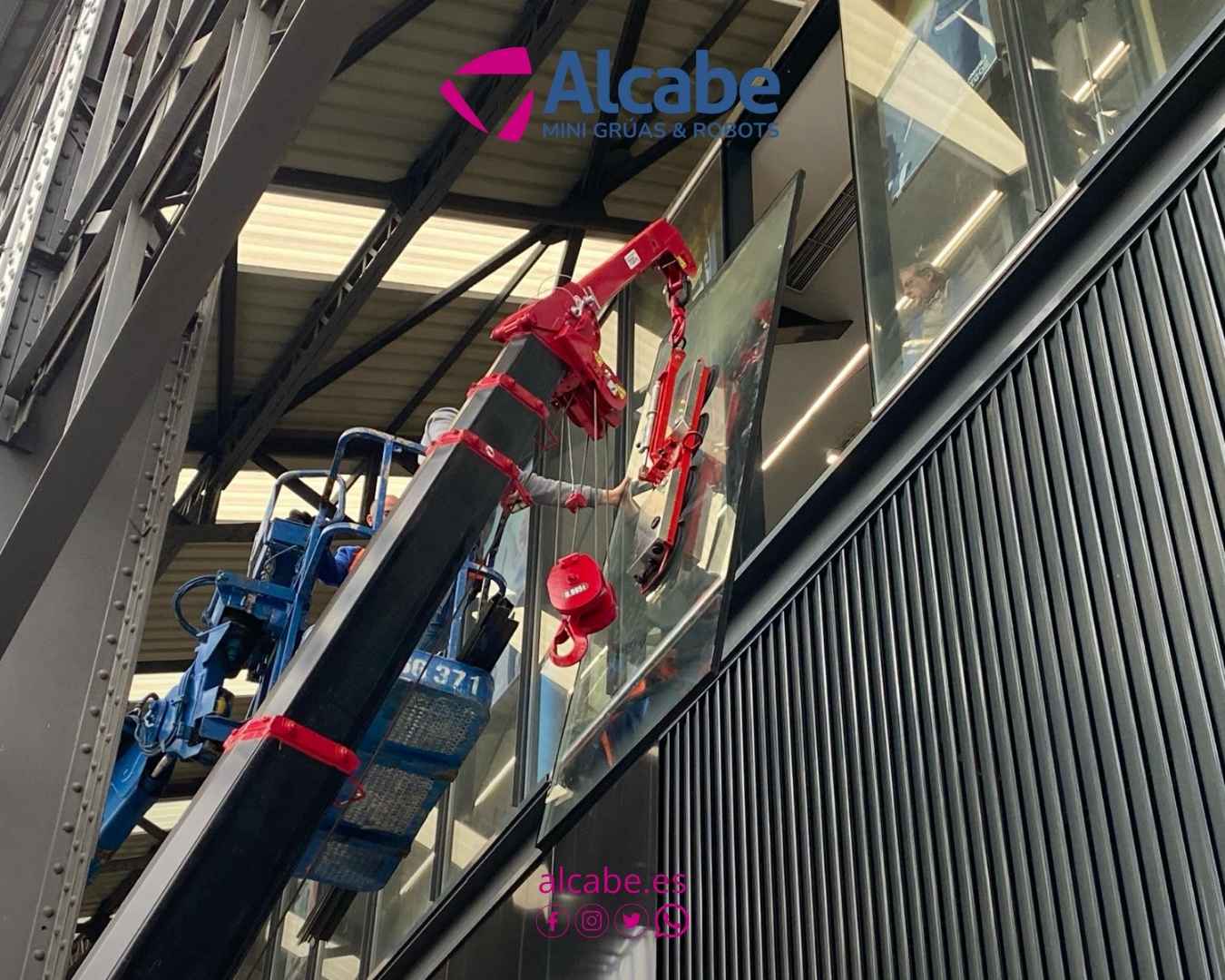 Mini grúa alquilada a ALCABE para la colocación de escaparate y vidriera exterior de toda la fachada del gimnasio Enjoy San Bernardo, en Sevilla